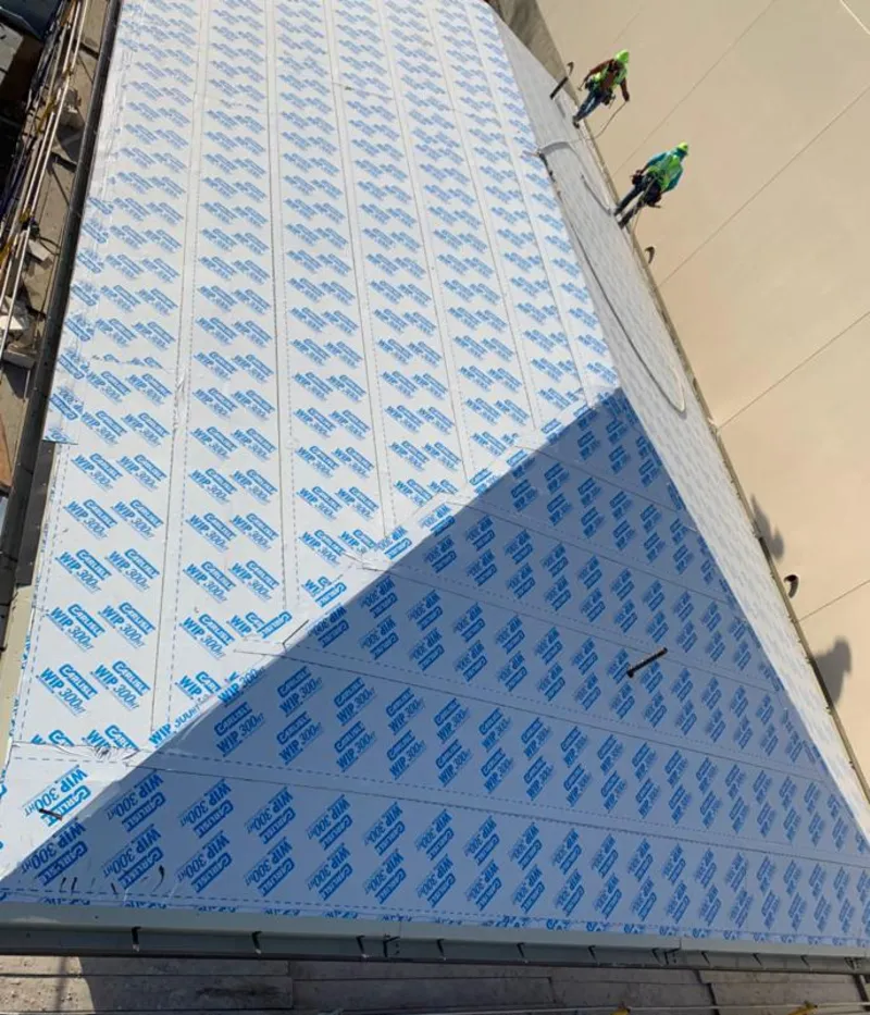 Professional roofers installing underlayment on a metal roof in Hopkinton